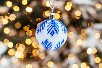 Wall Mural - Blue white christmas ball on fir tree branch close up golden yellow light bokeh background