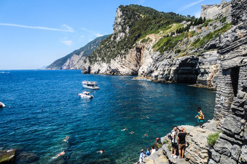 Portovenere. Entrance to the cave of Byron. Beautiful blue sea. Tourists bathing in the crystal clear sea. Boats with tourists