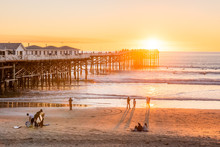 People Doing Activities At The Beach Near The Pier With Beautiful Sunset. Pacific Beach In San Diego, California
