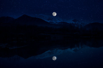 Wall Mural - landscape of gorgeous full moon over the snow-capped mountains reflected in the lake or mysterious n