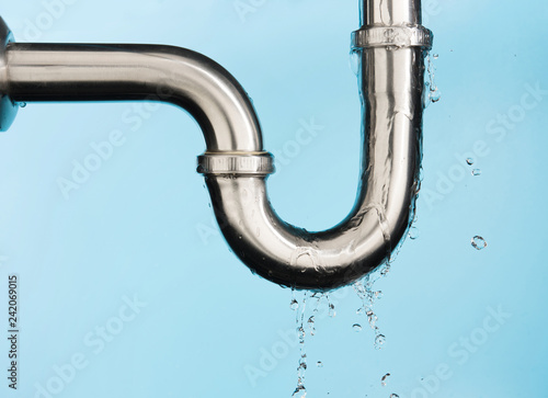 Cuadros en Lienzo Leaking of water from stainless steel sink pipe on isolated on light blue backgr