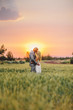 © maxwellmonty - bride and groom kissing in field at a fiery sunset