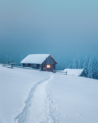 fantastic winter landscape with wooden house in snowy mountains. christmas holiday concept. carpathi