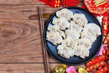 Wall Mural - Chinese Jiaozi new year food, spring festival food on traditional spring festival Spring festival atmosphere and dumplings, ang pow or red packet and gold ingots. Chinese characters means luck,wealth