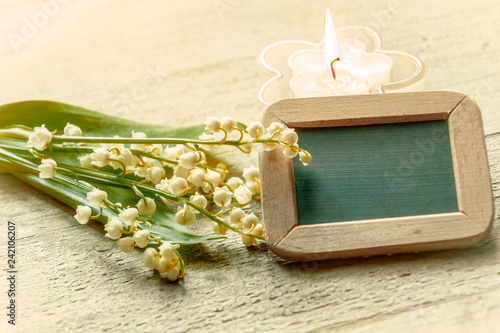 Fotografie, Obraz Kleine Tafel mit Kerze und Blumen, Dekoration mit Maiglöckchen