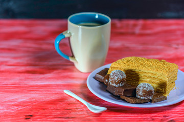 A mug of fresh coffee, on a red wooden background.