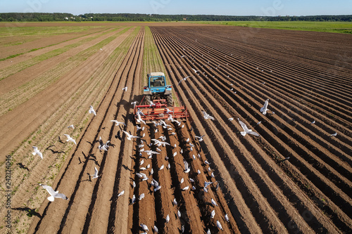 Foto Agricultural work on a tractor farmer sows grain