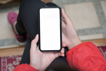 Girl with a blank screen mobile smartphone in her hands