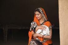 Indian Womanwith Baby Goat In Rural House