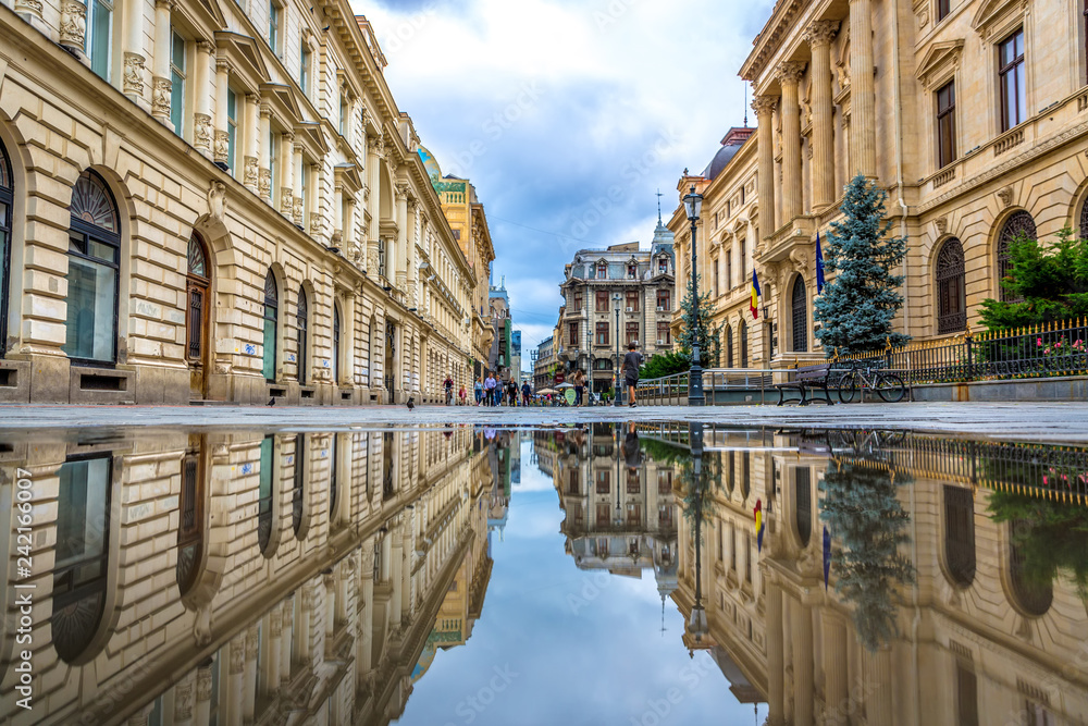Obraz na płótnie Bucharest, Romania - July 6th 2018 - The old town of Bucharest seen through a water reflection with people in the background in Romania w salonie