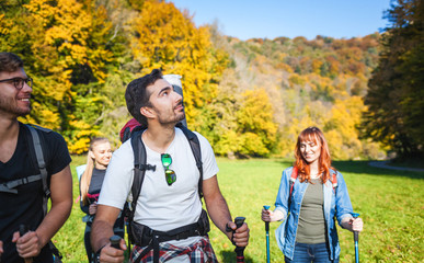 Wall Mural - smiling man trekking with friends in the nature, hikers exploring places