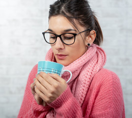 Poster - young brunette woman dressed in pink drinking a cup of tea