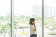 © Quang - Woman talking on cellphone near window background