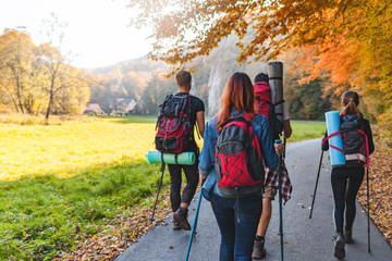 Wall Mural - friends with backpacks walking outdoor together, trekking and tourism