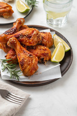 Wall Mural - Chicken legs with sauce, rosemary and lime on a white background. Copy space.