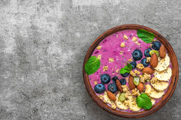 Healthy breakfast. acai smoothie bowl with banana, blueberry, granola, almonds, pumpkin and chia seeds