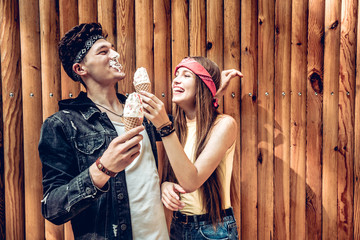 Couple having fun together. The girl jokingly smeared ice cream to her friend in the face. They laugh together.