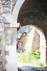 Wall Mural - The girl climbs the stone wall.