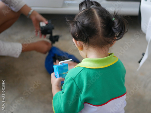 Fotografía Little Asian baby girl interested in her mother pumping air into a rocking doll