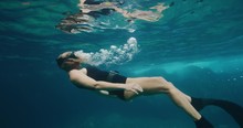 Beautiful Woman Free Diver Swimming Underwater Blowing Bubbles Under The Surface