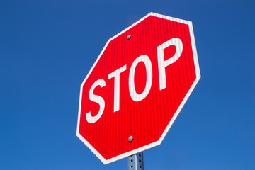 Stop sign with brilliant blue skies in the background.