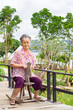 © meeboonstudio - Elderly woman sitting on wooden rocking horse.