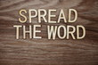 Spread the Word alphabet letters on wooden background