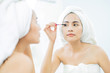 © torwaiphoto - Asian beautiful women applying black mascara eyelashes after bathing