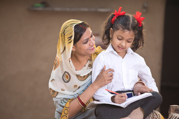 Wall Mural - Rural mother helping daughter with her homework