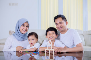 Wall Mural - Young family playing with wood blocks