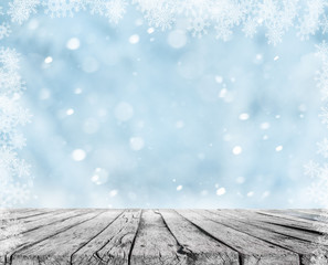 Wall Mural - a wooden table and winter snow background with snowflakes