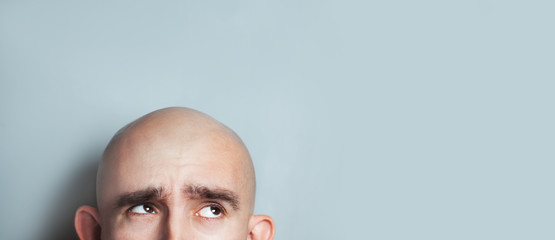 Emotional portrait of surprised bald man. half-face. Copyspace for text.