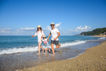 Happy family enjoying on beach. Summer vacation, family with one child having fun on beach