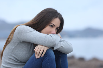 Wall Mural - Sad girl looking away alone on the beach