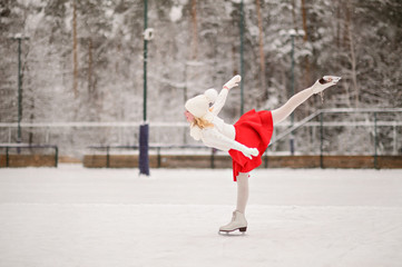 Child young girl ice skating at the ice rink outdoor