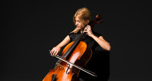 Young Girl Playing The Cello On Isolated Black Background