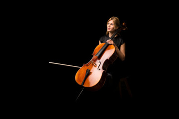 Wall Mural - Young girl playing the cello on isolated black background