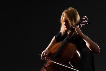 Wall Mural - Young girl playing the cello on isolated black background