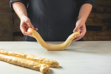 Wall Mural - Male baker making traditional challah jewish bread. Cooking steps process food concept.