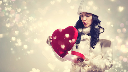 Wall Mural - Happy young woman holding a big heart gift box