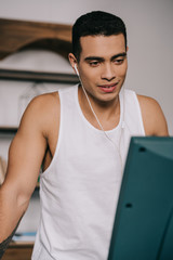 Wall Mural - smiling mixed race man listening music in earphones