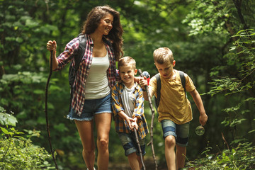 Mother and her little sons hiking trough forest.Spring concept.