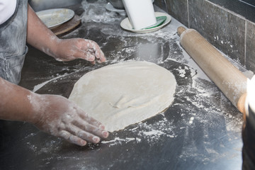 Wall Mural - Hands preparing a pizza in the kitchen