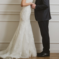 Wall Mural - Elegant bride and groom posing together in studio on a wedding day.