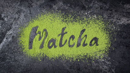 Lettering from green matcha tea on black marble background