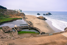 Ruins Of The Sutro Baths On A Cloudy Day; The Cliff House In The Background, Lands End, San Francisco, California