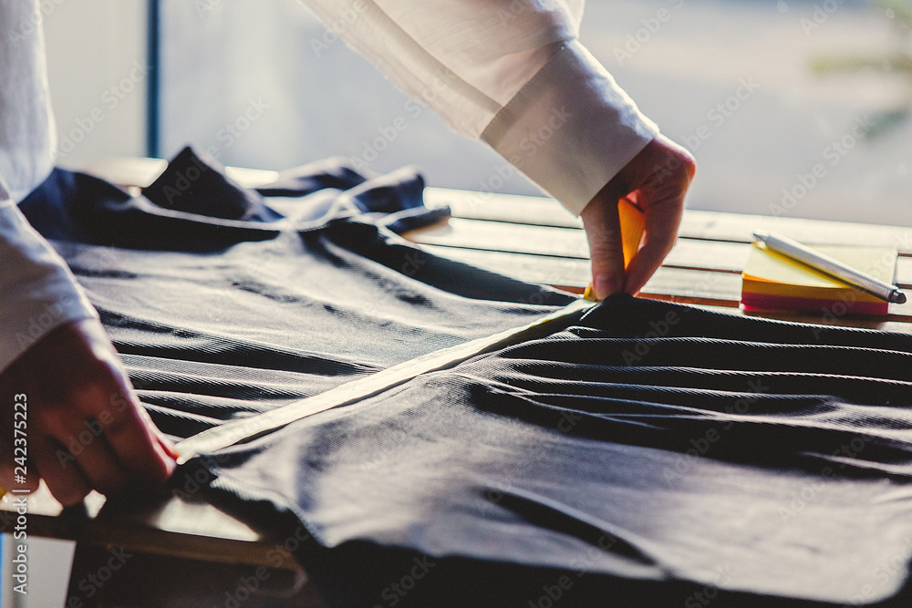 fashion designer hands with dress and measure tape. Side view