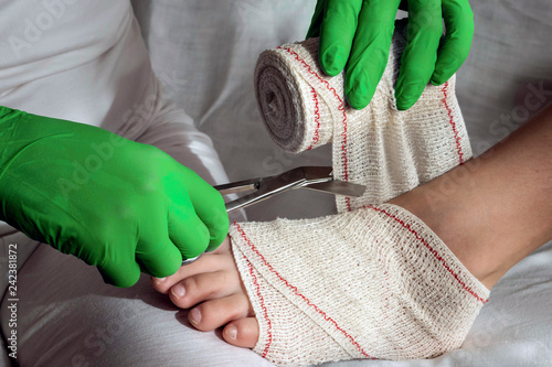 Fotografía Close-up Of A Nurse Tying Bandage On Patient's Foot