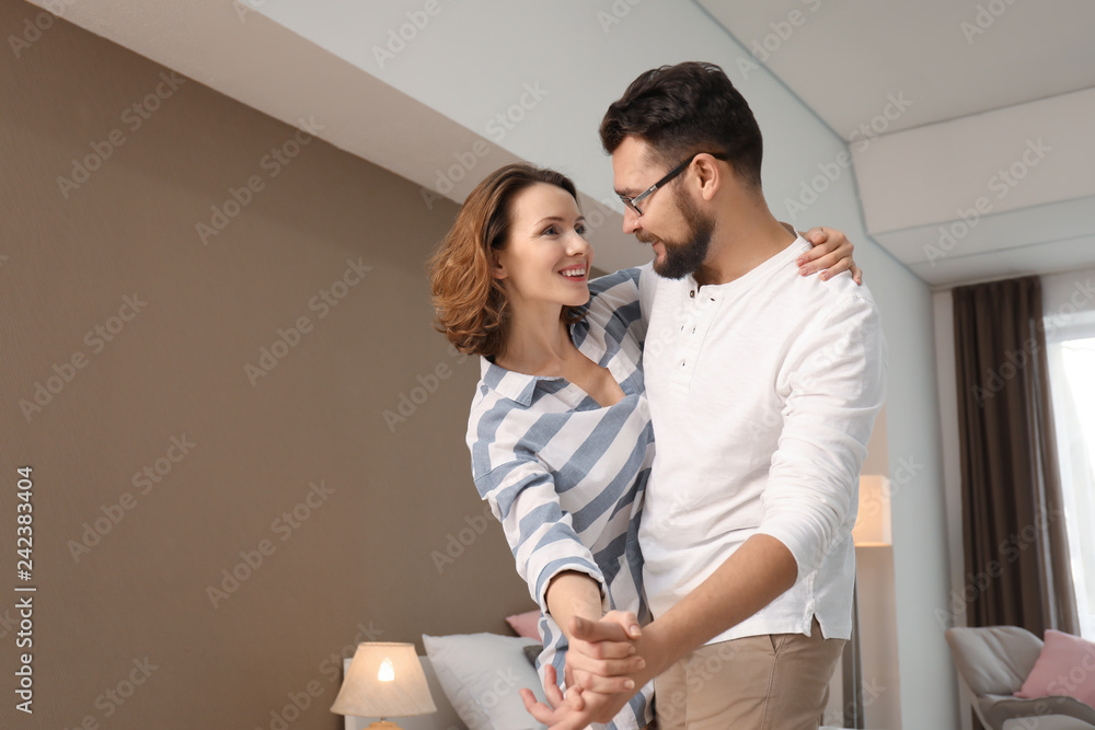 Lovely couple dancing together at home