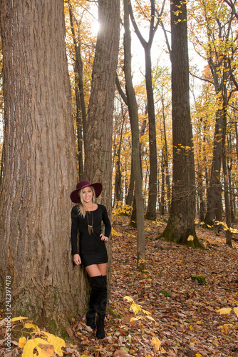 Sexy young blonde woman in stunning black dress and over the knee boots ...